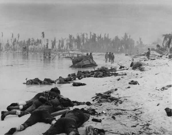 Photo: Bodys of fallen marines litter the beach as survivors walk in the distance.