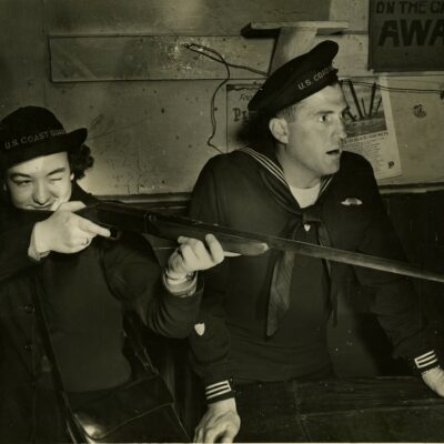 Photo: Seaman Marie Deppen aim rifle while Gunner's Mate looks on.