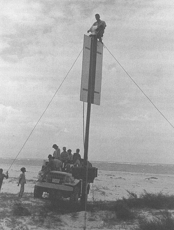 Photo: A man is positioned at the top of a range marker.