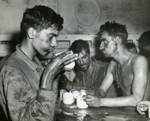 Photo: Weary and begrimed marines sipping coffee.