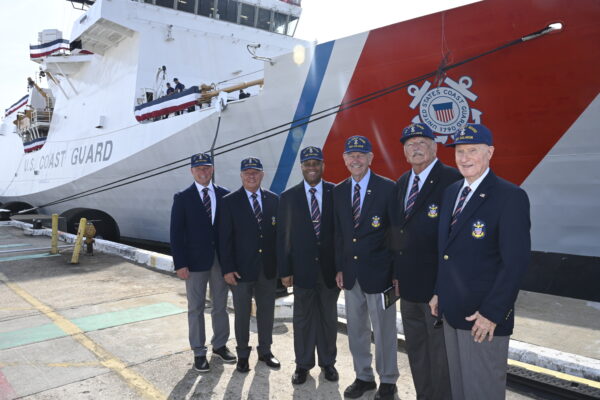 Photo: Former Master Chief Petty Officers of the Coast Guard stand in front of the Coast Guard Cutter Calhoun.