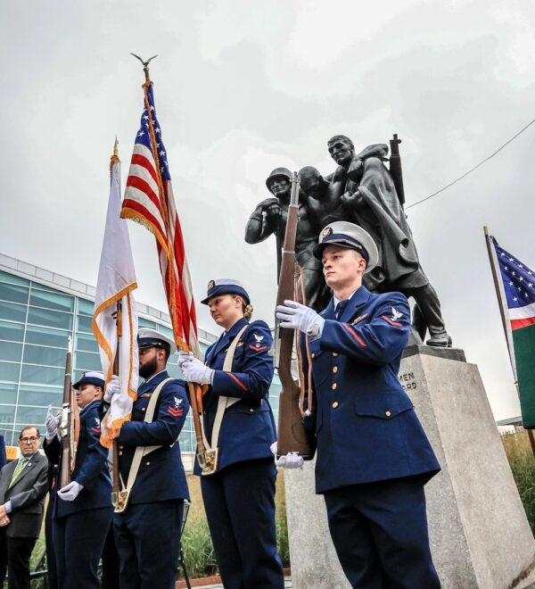 Photo: Color guard stand in front of stature.