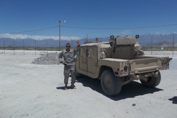 Photo: Men standing with Humvee.