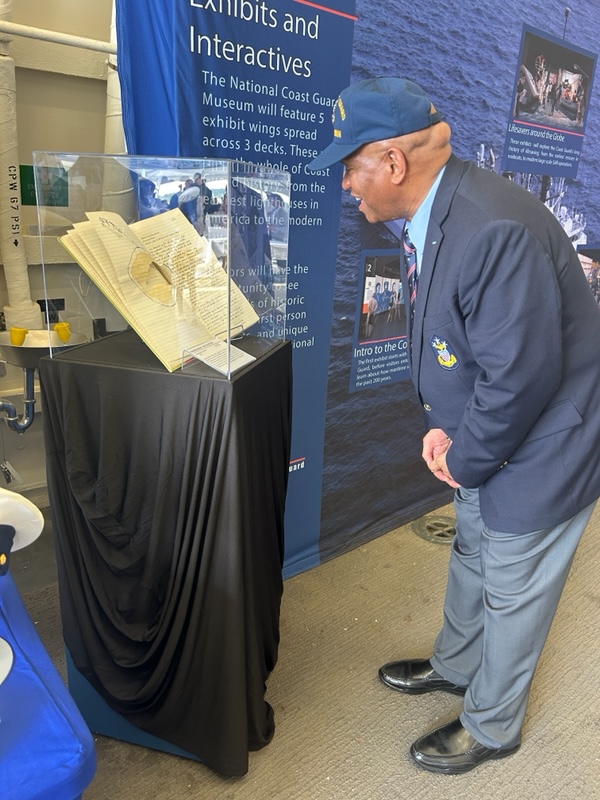 Photo: Retired Master Chief Petty Officer of the Coast Guard Vince Patton admires views an artifact.
