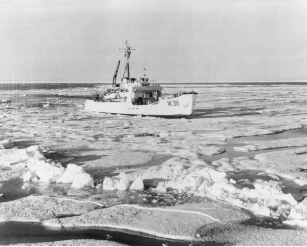 Photo: A ship, marked W38, breaking through icey water.