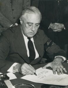 Photo: President Roosevelt signs the Declaration of War against Japan.