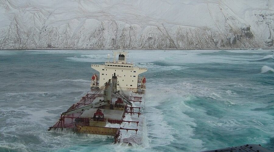 Photo: The Selendang Ayu sinking into icy water with snow-covered Unalaska Island in the background.