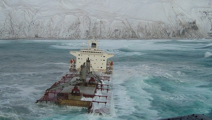 Photo: The Selendang Ayu sinking into icy water with snow-covered Unalaska Island in the background.