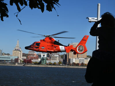 Photo: A U.S. Coast Guard MH-65 Dolphin helicopter hovers above the water.