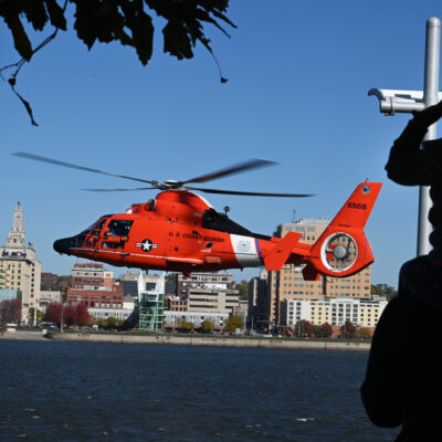 Photo: A U.S. Coast Guard MH-65 Dolphin helicopter hovers above the water.