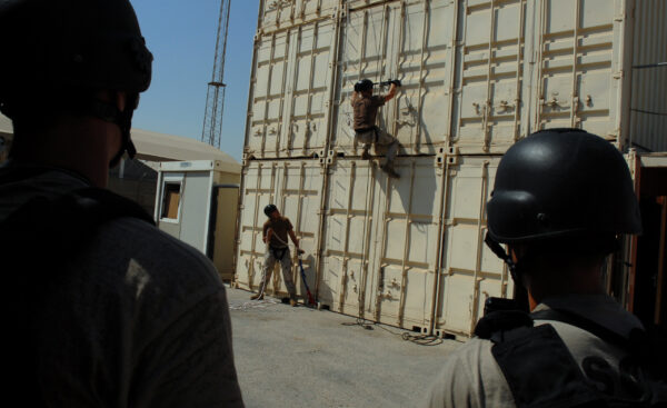 Photo: Men climbing cargo containers.